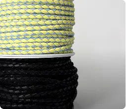 Deux bobines de cordons tressés, l’un jaune et blanc, l’autre noir — Maison Satab