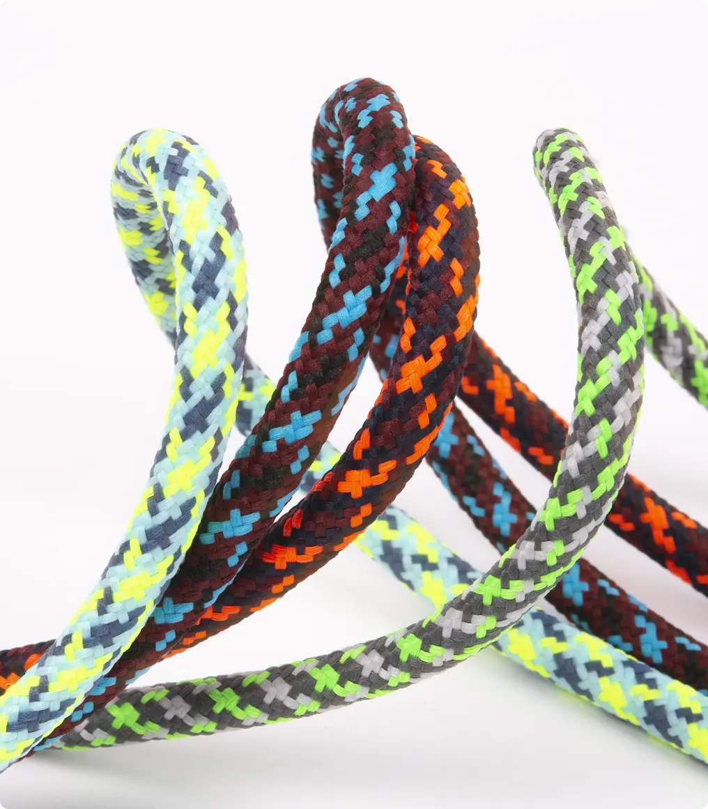 Cordons tressés à motifs chevrons entrelacés, tons jaune fluo, orange, bleu et vert anis, sur fond clair — Maison Satab