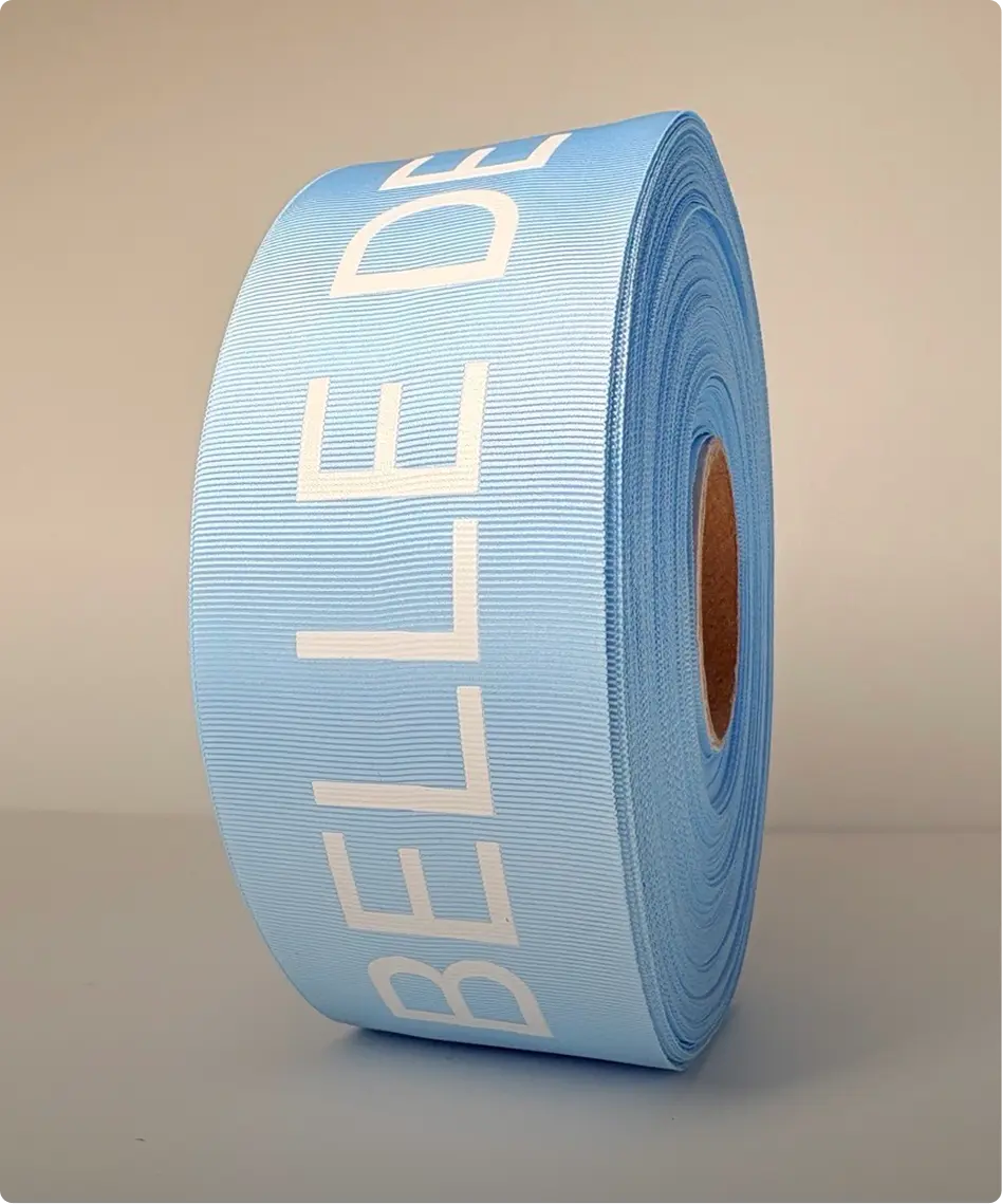 Rouleau de ruban gros-grain bleu ciel imprimé d’un lettrage blanc en capitales — Maison Satab