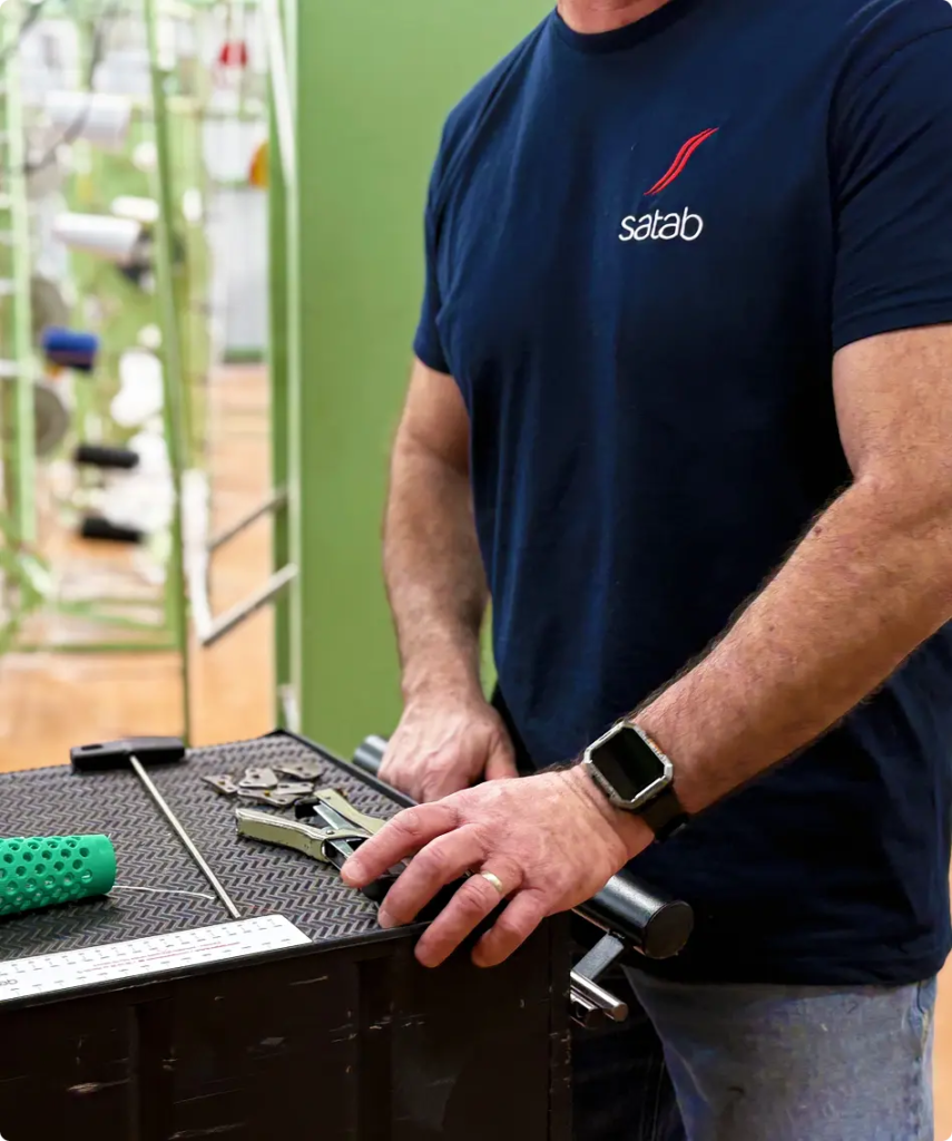Technicien en polo Satab réglant une machine à l’atelier de production — Maison Satab
