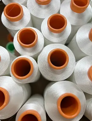 Cônes de fil blanc à mandrin orange vus du dessus — Maison Satab