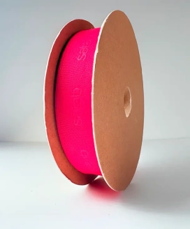 Bobine carton de ruban rose fluo posée sur la tranche, doublée d’un ruban rouge — Maison Satab